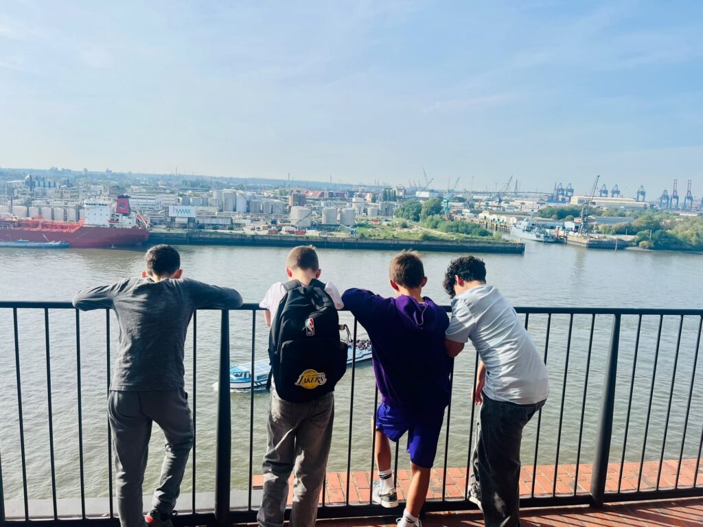 Kinder von hinten auf der Plaza mit Blick über den Hafen