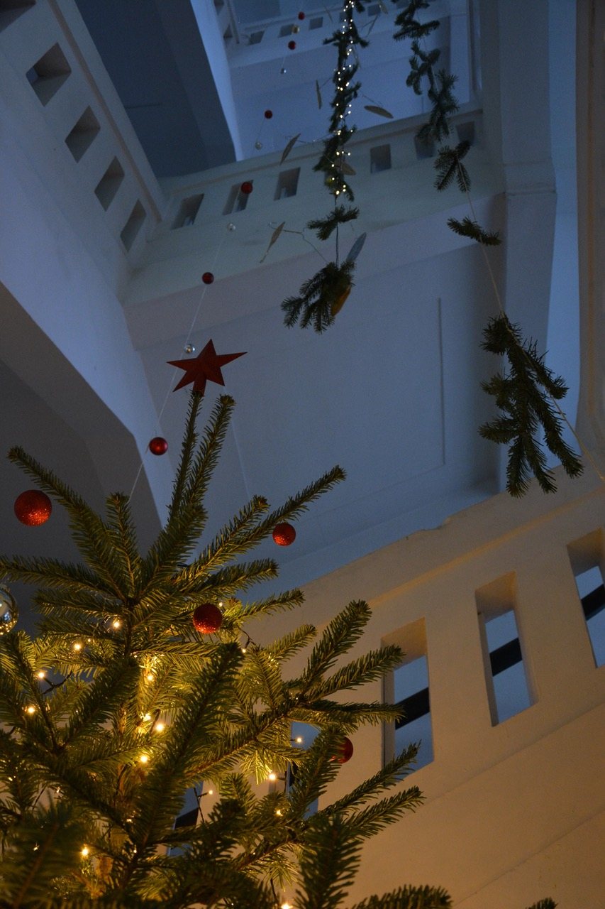Weihnachtlich geschmückter Tannenbaum im Treppenhaus der Schule.