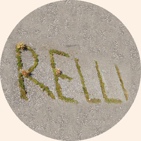Das Wort RELLI aus Moos auf einer Steinfläche.